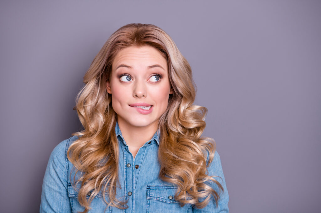 Woman with white teeth looking worried. 