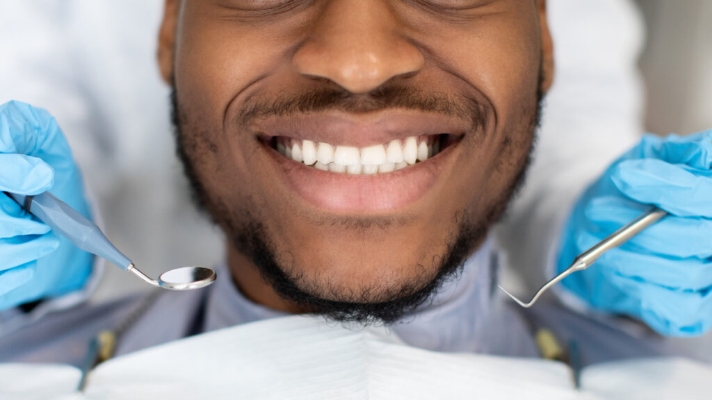 Man with healthy teeth smiling at dentist